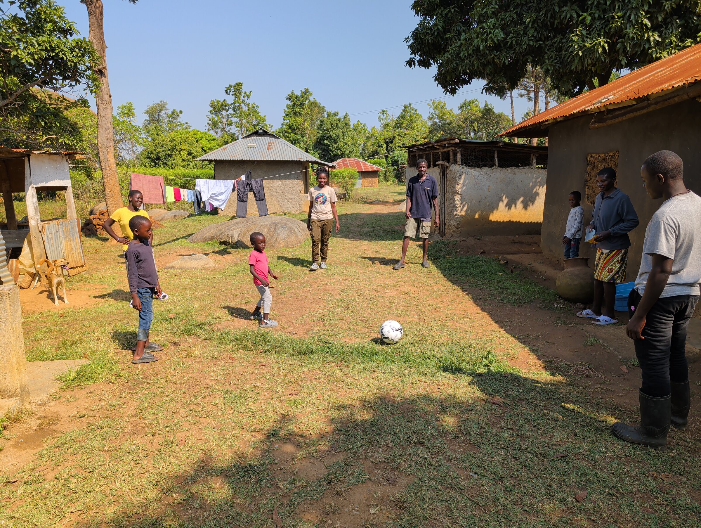 Kids und Erwachsene spielen gemeinsam Fußball in der Community